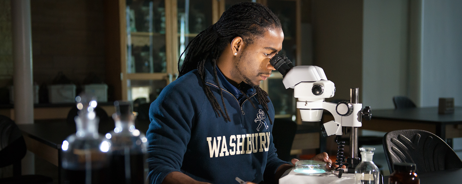 Student looking through microscope